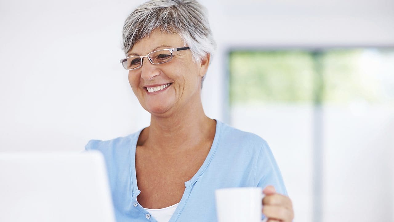 Smiling woman using laptop at home