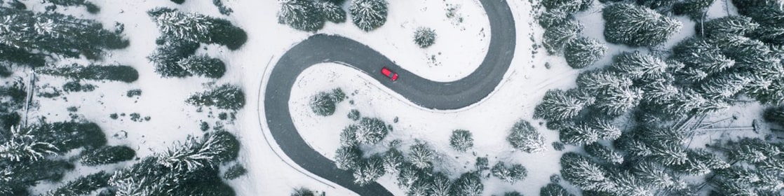 Aerial view of winding road in winter forest