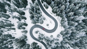 Aerial view of winding road in winter forest