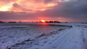 Sunrise on a snowy road and field