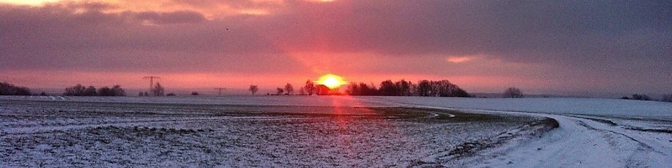 Sunrise on a snowy road and field