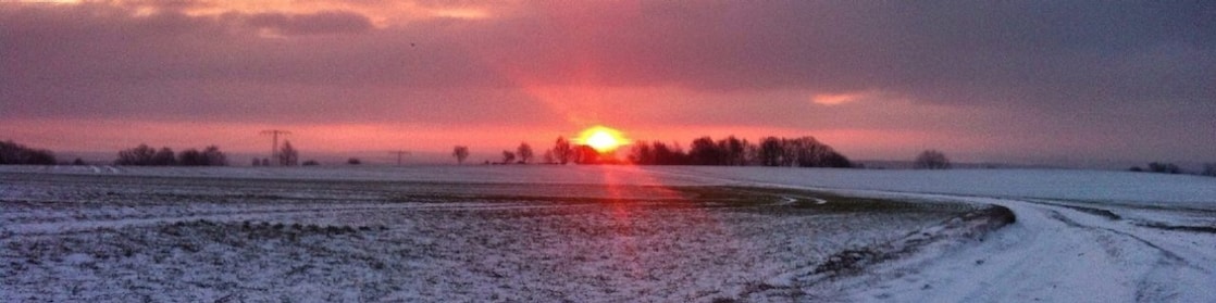 Sunrise on a snowy road and field