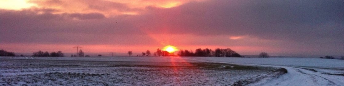 Sunrise on a snowy road and field