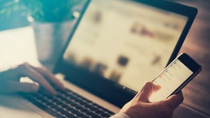 Man using laptop and phone